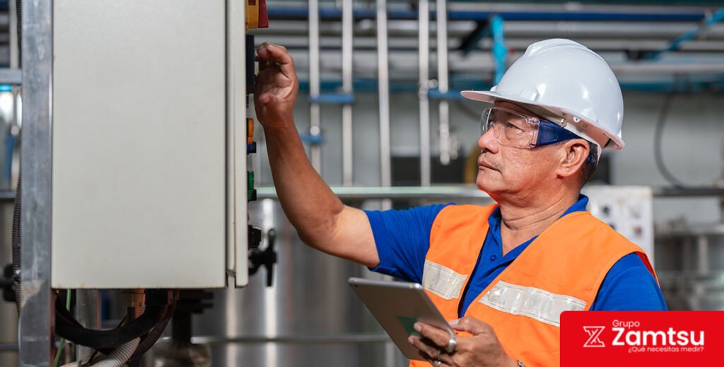 Operario verificando panel industrial para control de gases tóxicos en planta de procesos
